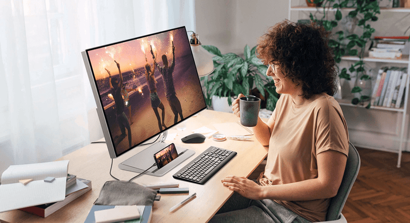 Glückliche Frau am Arbeitsplatz mit Lenovo Geräten