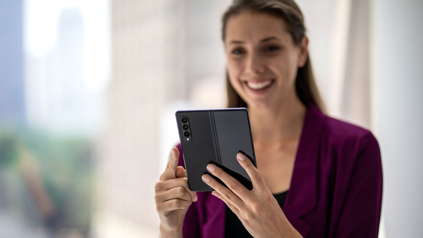 Frau arbeitet zufrieden mit ihrem Samsung Device