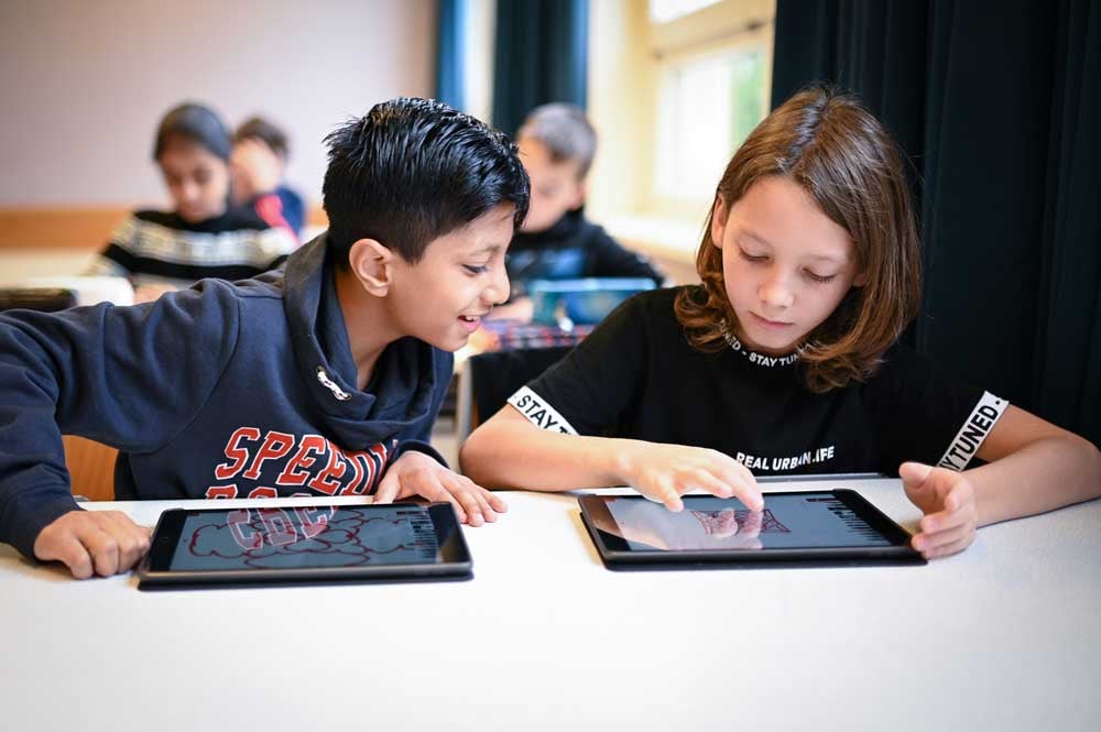 Schüler*innen arbeiten mit iPads im Unterricht