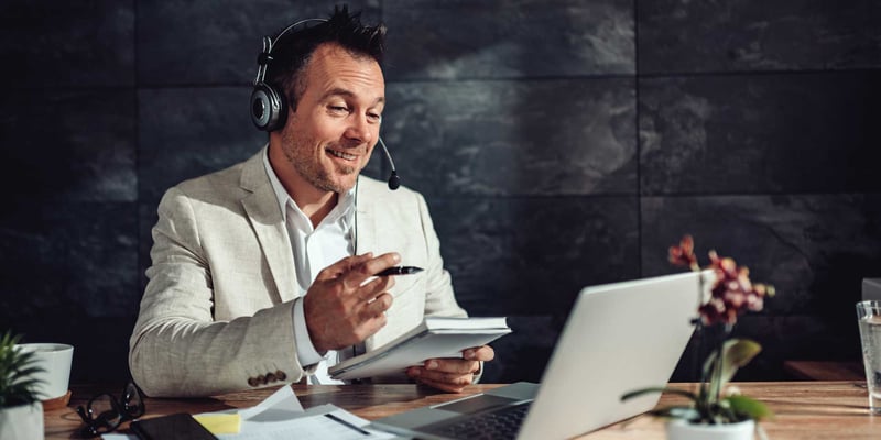 Mann im Online-Meeting mit Headset und Laptop