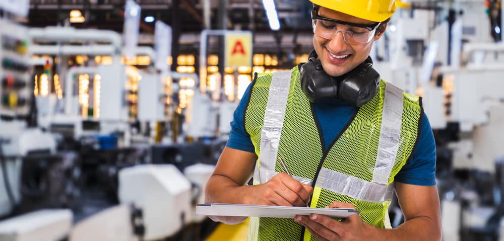 Mitarbeiterin in einer Produktion lächelt bei der Arbeit | ACP - IT for innovators.