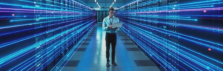Mann steht bei modernem Rechenzentrum | ACP - IT for innovators.