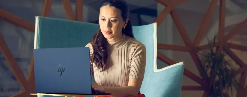 Frau arbeitet in modernem Büro auf einem HP EliteBook G1i. | ACP - IT for innovators.