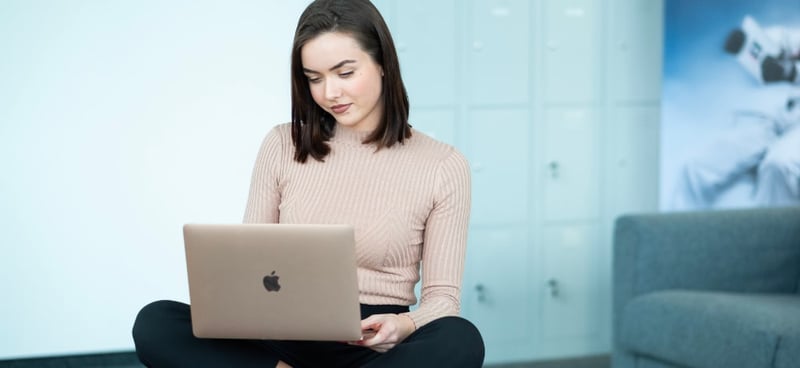 Junge Frau arbeitet auf MacBook. ACP - IT for innovators.