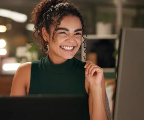 Frau arbeitet mit KI-gestützten Funktionen von Adobe Express auf Monitor