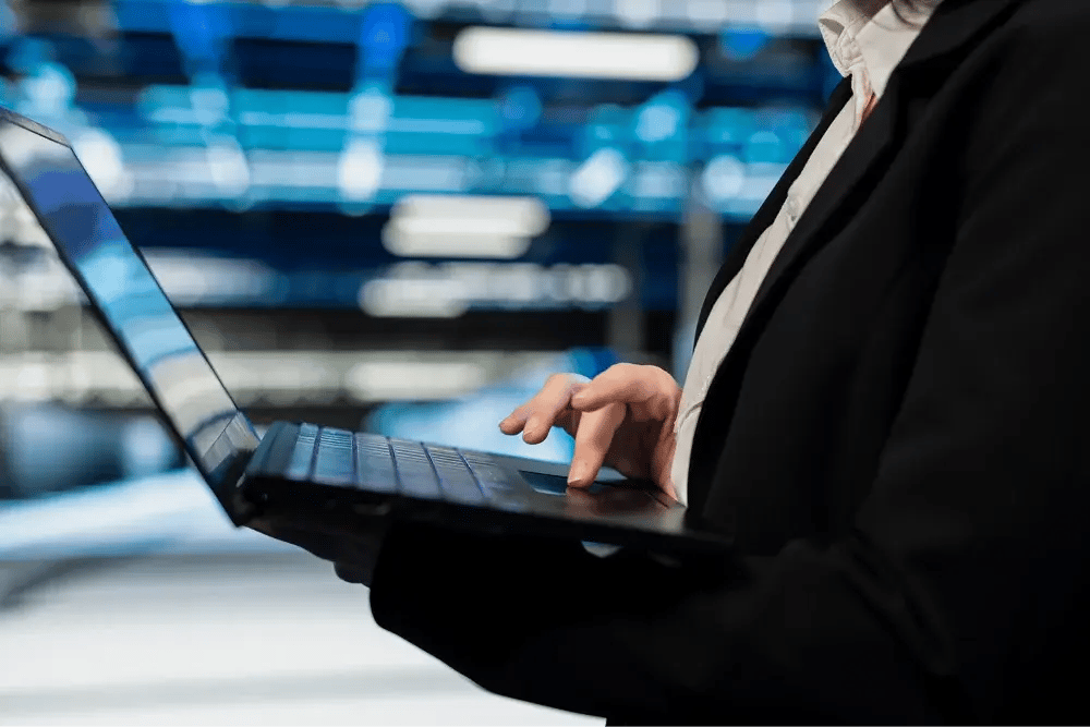 Frau arbeitet auf Laptop mit Microsoft 365 E7 Lizenz